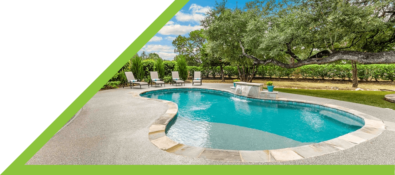 freeform backyard pool with stone coping and surrounding lounge chairs
